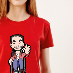 Camiseta manga curta FEMININA na cor vermelha, no centro o Tom, personagem do blog, homem cadeirante, com barba sorrindo e acenando com a mão esquerda, usa uma camisa de manga longa rosa, outra por dentro branca, calça jeans azul e sapatos pretos. Zoom na modelo, mulher branca, cabelos compridos e loiros.