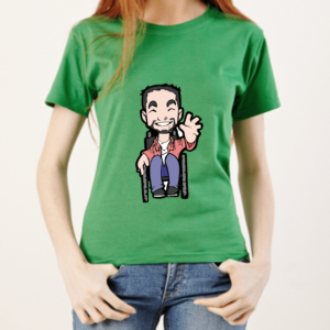 Camiseta manga curta FEMININA na cor VERDE, no centro o Tom, personagem do blog, homem cadeirante, com barba sorrindo e acenando com a mão esquerda, usa uma camisa de manga longa rosa, outra por dentro branca, calça jeans azul e sapatos pretos. Modelo, mulher branca, cabelos compridos e loiros com as mãos nos bolsos de uma calça jeans azul.